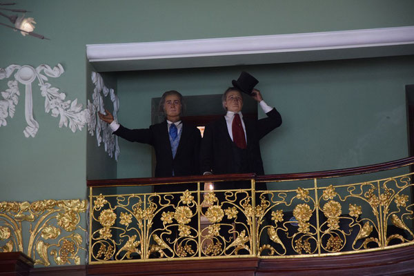 Figuren auf dem Balkon im Delikatessenladen